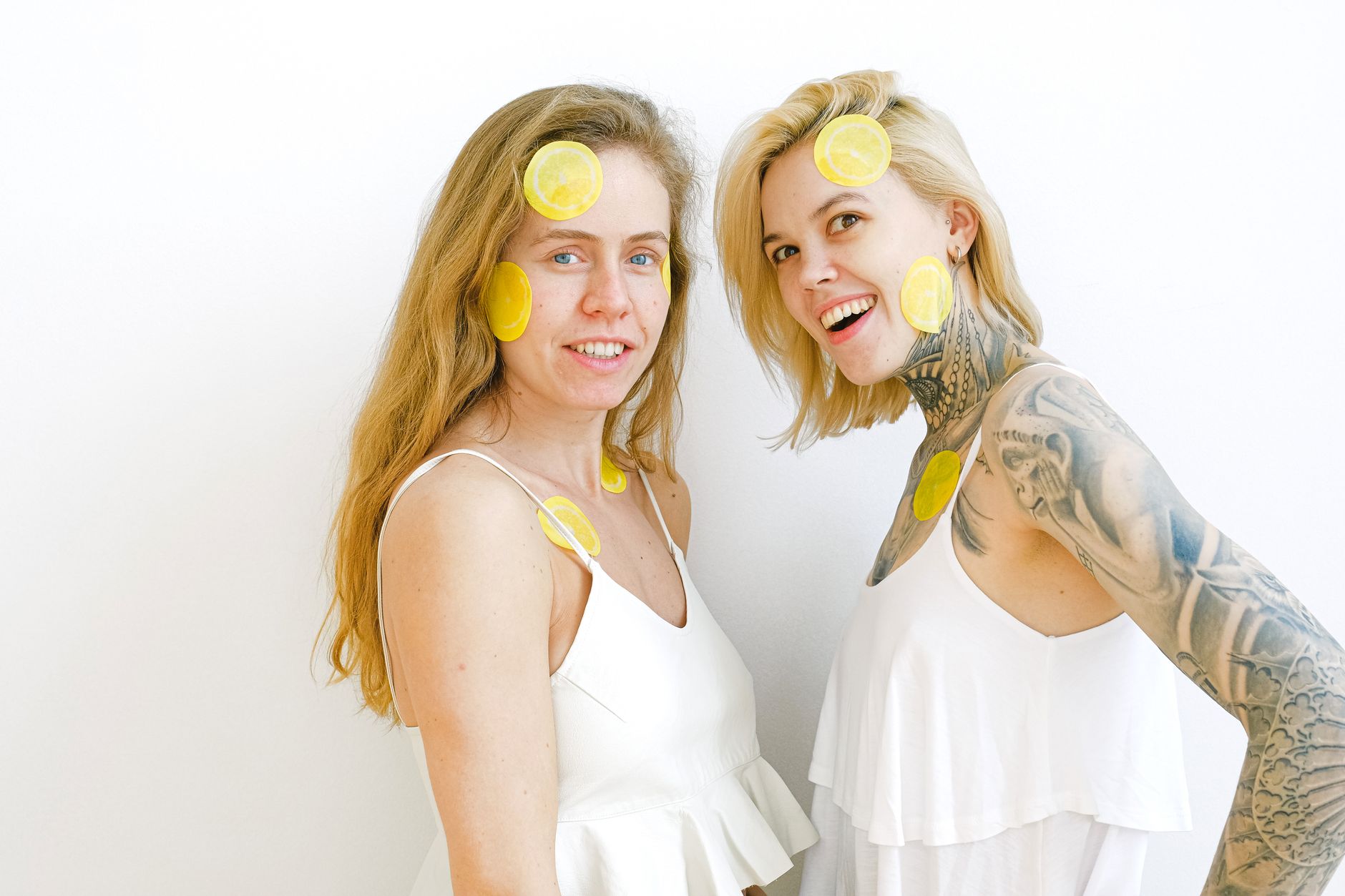 Hand holding a fresh lemon against a bright yellow background, symbolizing renewal and citrus freshness