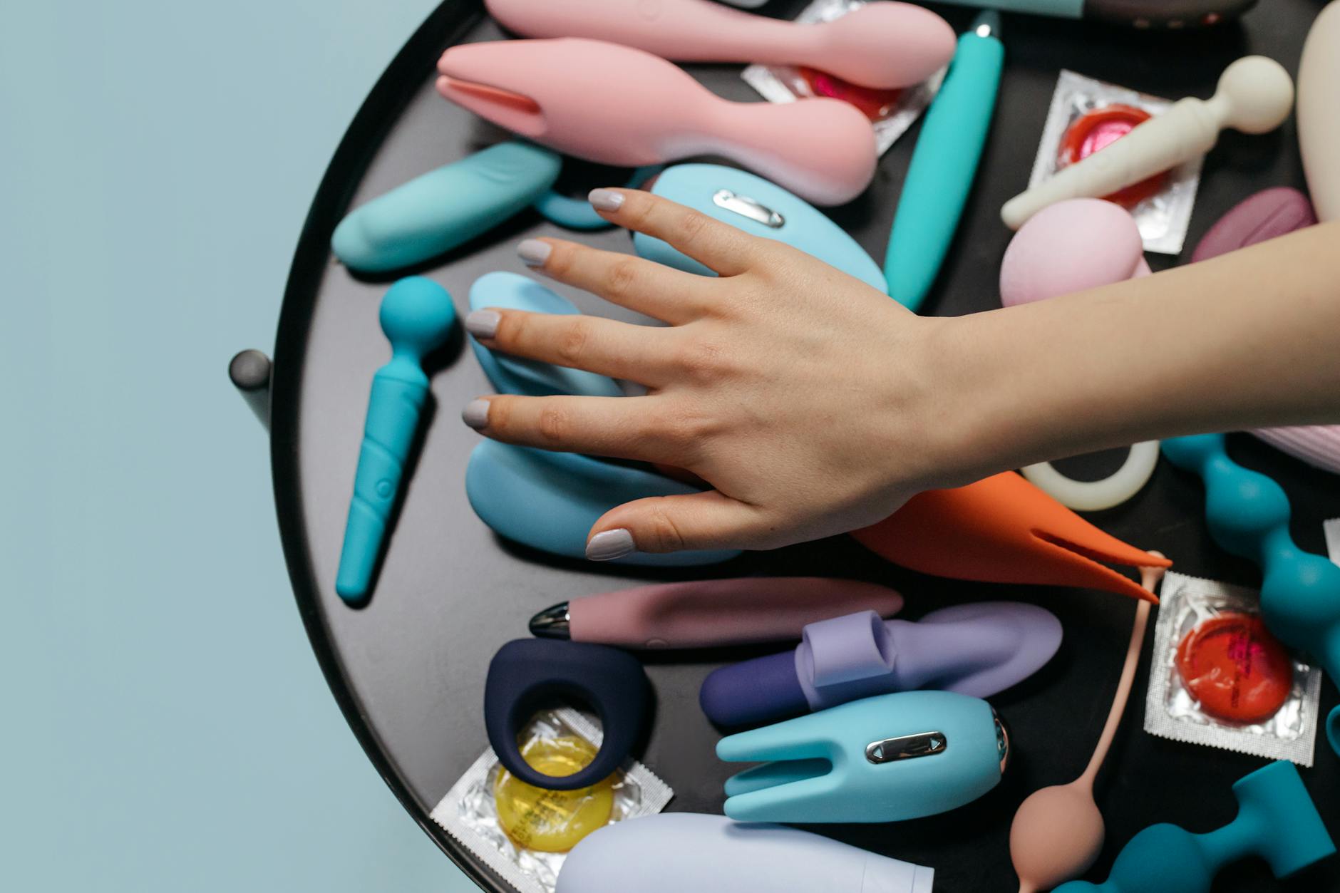 A woman holding a vibrator with art books nearby, representing intimate reconnection